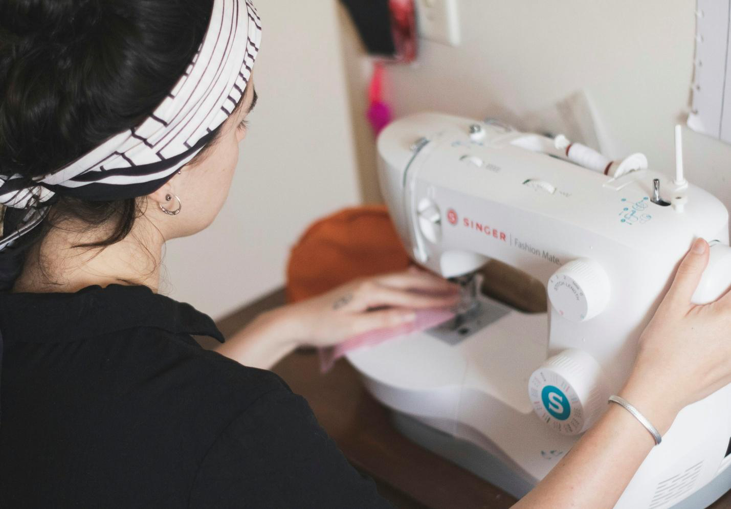 A person stitching a garment using machine